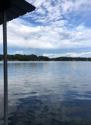 A calm lake with a clear sky and a distant shoreline. - Castle Cove Lakefront Home (Goreville)