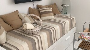 A modern room with a bed, a flat-screen TV, a desk with a lamp, and a shelf with a bottle. - Apartment Oleander - One Bedroom Apt with Terrace (Novalja)