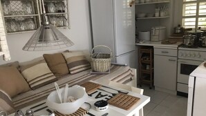 A kitchen with a refrigerator, stove, and shelves with kitchenware. - Apartment Oleander - One Bedroom Apt with Terrace (Novalja)