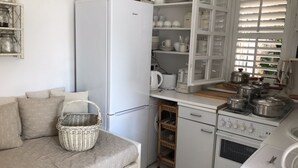 A compact kitchen with a refrigerator, stove, and various kitchenware. - Apartment Oleander - One Bedroom Apt with Terrace (Novalja)