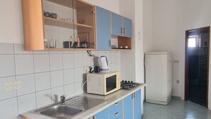 A compact kitchen with a sink, a microwave, a stove, and cabinets.