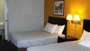 Una habitación de hotel con dos camas, un cuadro en la pared y dos lámparas de noche.