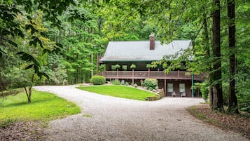 Situated in a forested area, this lodge features a balcony and a chimney.
