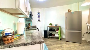 A kitchen with a granite countertop, stainless steel appliances, and a wooden floor. - ❤️Amazing Round House, Ground Floor Unit, Easy Walk To The Beach, Self Check-In (Carolina Beach)