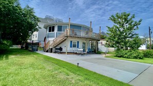 A two-story house with a covered patio, a staircase, and a barbecue grill. - ❤️Amazing Round House, Ground Floor Unit, Easy Walk To The Beach, Self Check-In (Carolina Beach)