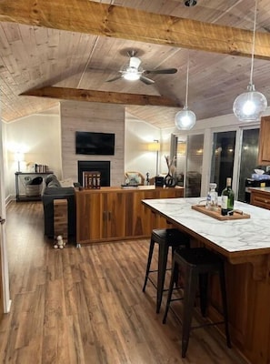 A spacious kitchen with wooden cabinets, a marble countertop, and a ceiling fan. - The R&R Cottage (Minden)