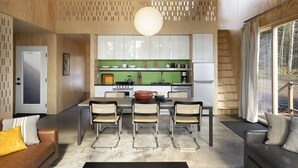 A modern kitchen with a dining area, wooden walls, and a large window. - Scandinavian Chalet with Sauna Lutsen - Green (Lutsen)