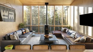 A modern living room with large windows, a fireplace, and a flat-screen TV. - Scandinavian Chalet with Sauna Lutsen - Green (Lutsen)
