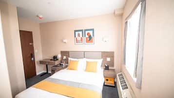Een hotelkamer met een bed, nachtkastjes, een verwarming en kunst aan de muur.