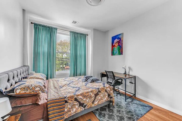 A bedroom with a bed, a desk, a chair, and a window with curtains. - Charming 3BHK - 15 mins bus ride to Time Sq., NYC (West New York)