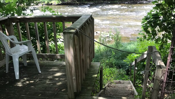 A wooden deck with a bench and a metal object, overlooking a river. - Cozy convenient home, private access to the Salmon River. (Pulaski)