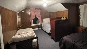 A bedroom with two beds, a wooden dresser, a desk, and a window with curtains. - Cozy convenient home, private access to the Salmon River. (Pulaski)