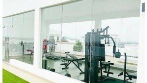 Ein Fitnessstudio mit Trainingsgeräten und großen Fenstern.