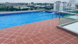 Ein Pool auf dem Dach mit freiem Blick auf die Skyline im Hintergrund.