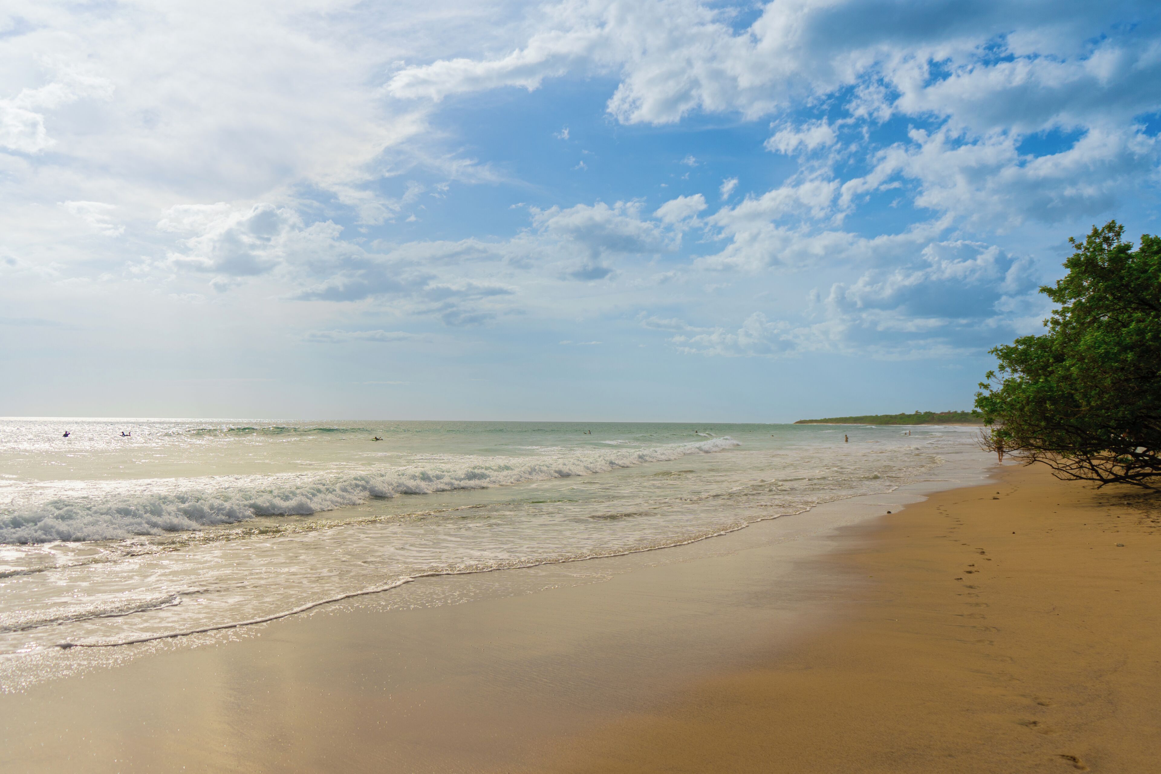Een strand met een zandstrand en golven.