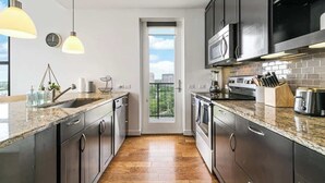 Una cocina moderna con encimeras de granito, electrodomésticos de acero inoxidable y vistas al exterior.