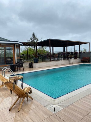 Piscine extérieure, parasols de plage, chaises longues