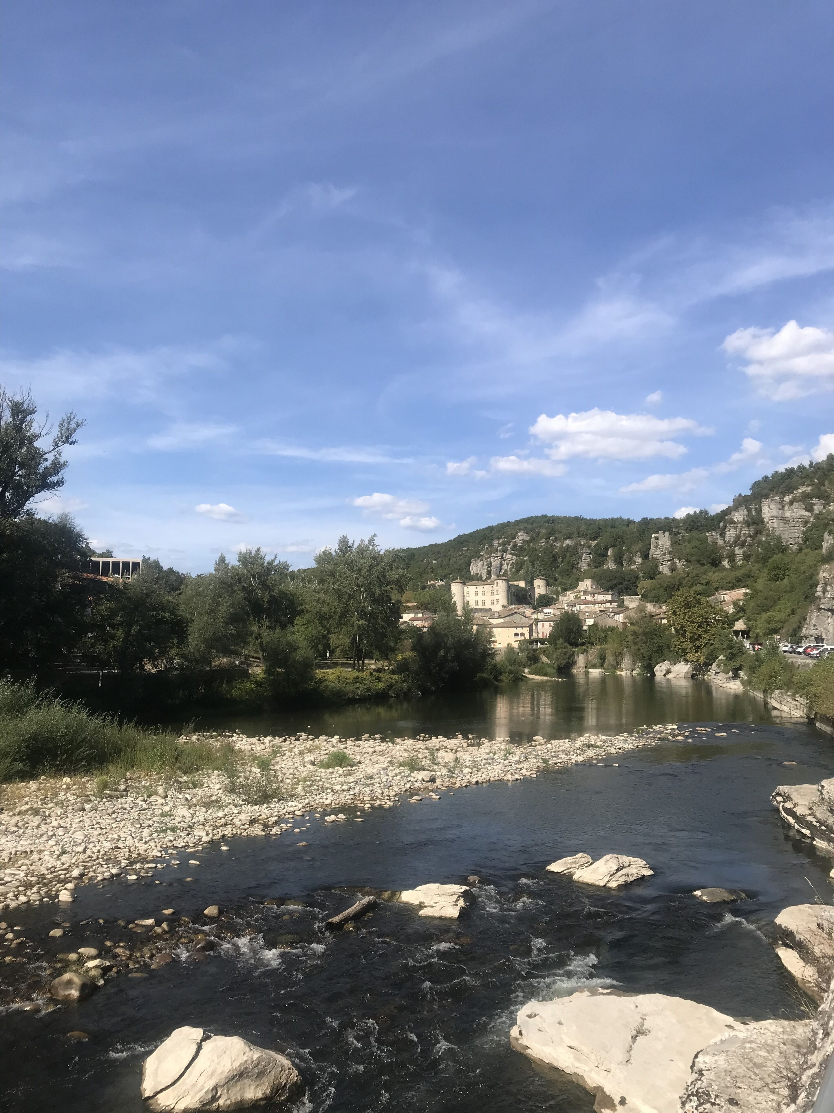 A river with rocks and a town in the background.