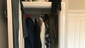 A closet with hanging clothes, a folded blanket, and a door. - Studio with a view, great transport links to central London (London)