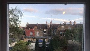 A view of terraced houses with brick facades and pitched roofs, visible through a window. - Studio with a view, great transport links to central London (London)