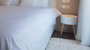 A modern bedroom with a large bed, a bedside table, and a wall-mounted light fixture. - ELEGANT HOUSE WITH ACROPOLIS VIEW (ΑΘΗΝΑ)