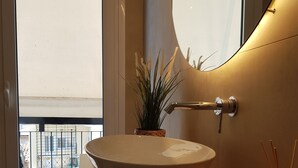 A bathroom with a large oval sink, a potted plant, and a mirror. - ELEGANT HOUSE WITH ACROPOLIS VIEW (ΑΘΗΝΑ)