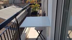 A balcony with a white table and two chairs, a potted plant, and a view of the cityscape. - ELEGANT HOUSE WITH ACROPOLIS VIEW (ΑΘΗΝΑ)