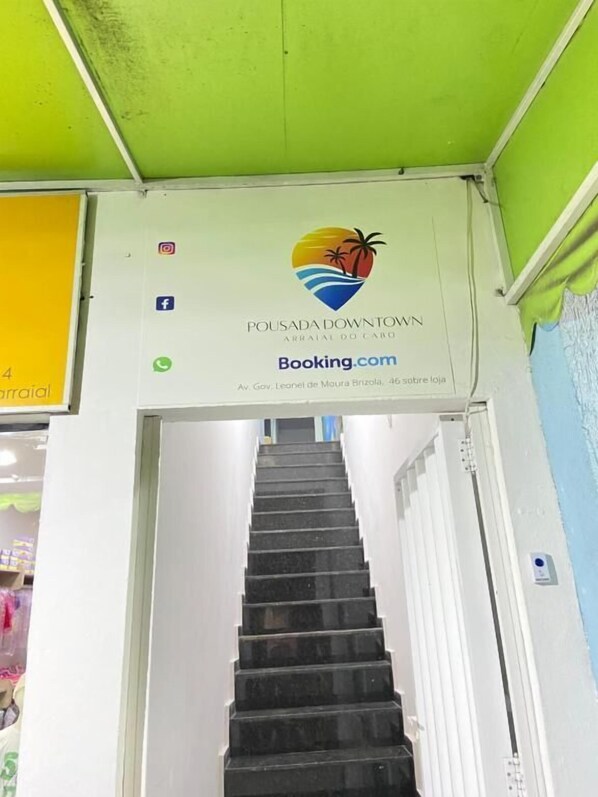 A staircase leading to a room with a sign for Pousada Downtown, indicating a booking option.