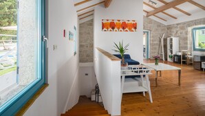 Un interior moderno con una escalera de madera, un comedor con mesa y sillas, y una cocina equipada.