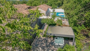 Una propiedad residencial con piscina, jacuzzi y zona de patio cubierta.