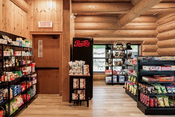 A store with shelves stocked with snacks and a Pepsi refrigerator.