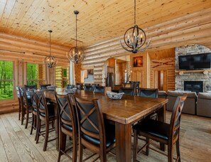 A log cabin interior with a dining area, kitchen, and living room. - Fiddler Lake Resort - Elk 96 (Mille-Isles)