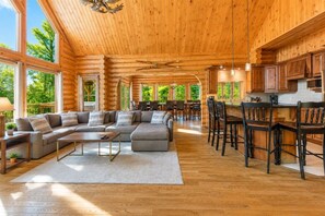A spacious log cabin interior with a large living area, dining space, and kitchen. - Fiddler Lake Resort - Elk 96 (Mille-Isles)