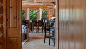 A wooden interior with a dining area, a sofa, and large windows. - Fiddler Lake Resort - Elk 96 (Mille-Isles)