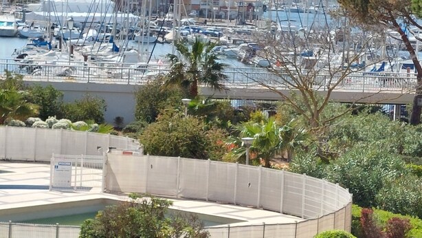 A marina with numerous boats docked, surrounded by buildings and greenery. - Meublé de Tourisme 3 Étoiles en Résidence Sécurisé (Cap d'Agde)