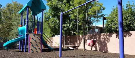 A playground with a slide, swings, and a climbing structure.