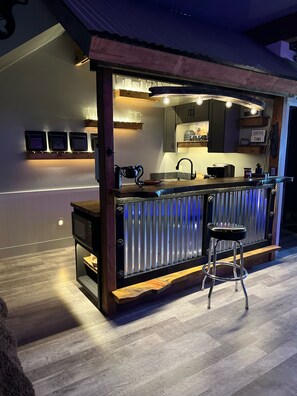Una cocina moderna con barra, electrodomésticos de acero inoxidable y mostrador de bar de madera.