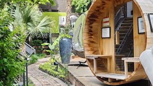 A wooden pod-style room with a built-in fan, a staircase, and a view of a lush garden. - Modern loft with king suite, resort pool, and historic charm in Swiss Avenue. (Dallas)