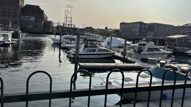 A marina with boats docked, wooden piers, and buildings in the background. - Yacht rental Downtown Providence (Providence)