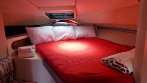 A compact bedroom with a single bed, a small table, and a patterned chair. - Yacht rental Downtown Providence (Providence)