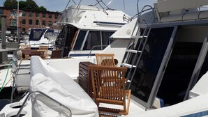 A marina with several boats docked, featuring covered seating areas and a clear view of the water. - Yacht rental Downtown Providence (Providence)
