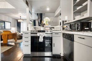 A modern kitchen with a built-in oven, dishwasher, and microwave. - Modern 3-bed loft with pool, courtyard, and prime walkable Dallas location. (Dallas)