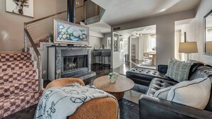 A spacious living room with a fireplace, a staircase, and a dining area. - Spacious loft with resort pool, courtyard, and prime Dallas location. (Dallas)