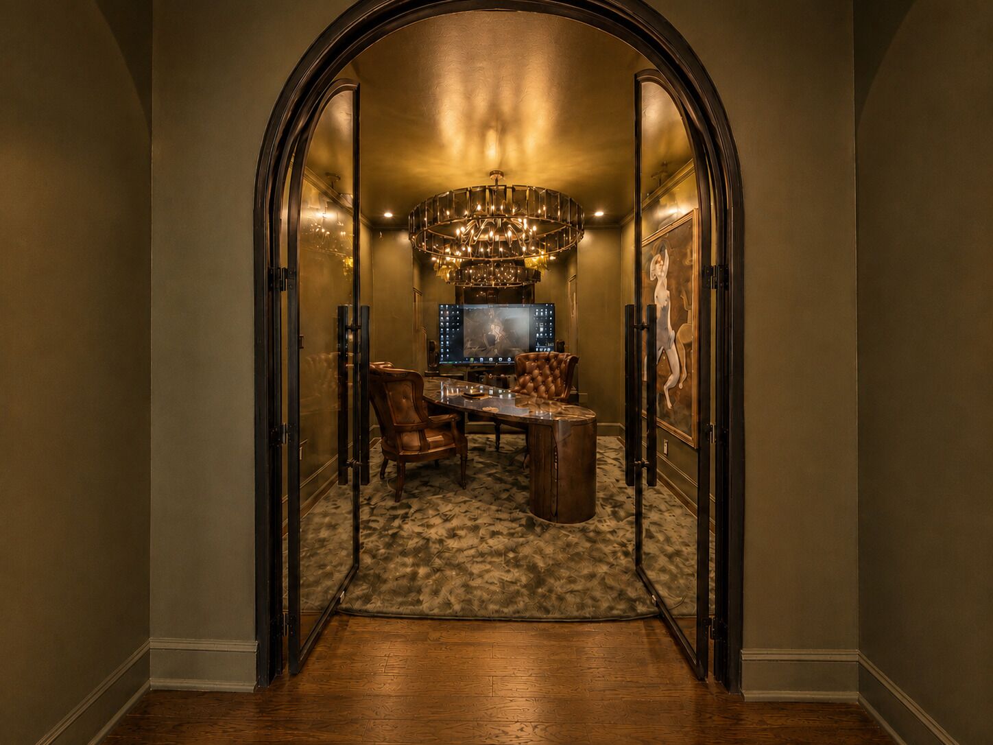 An arched doorway leading to a dining area with a chandelier, a television, and a framed artwork on the wall.