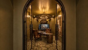 An arched doorway leading to a dining area with a chandelier, a television, and a framed artwork on the wall. - Spacious 2-story loft with king suite, fireplace, and resort-style amenities. (Dallas)