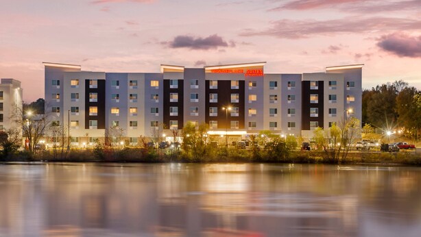 Ein modernes Hotel mit einer symmetrischen Fassade, mehreren Etagen und einem zentralen Eingang.