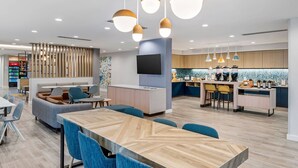 Eine moderne Hotelhalle mit Sitzgelegenheiten, einer Bar und einer Küche.