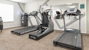 A fitness room with treadmills, a stationary bike, and a weight bench. - Capital Vacations Surrey Vacation Resort - 3 Bedroom (7-Night) (Branson)