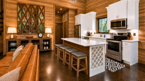 Una cocina moderna con armarios blancos, electrodomésticos de acero inoxidable y techo de madera.