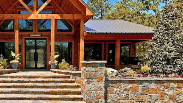 A wooden lodge with a prominent gabled roof and a welcoming entrance.